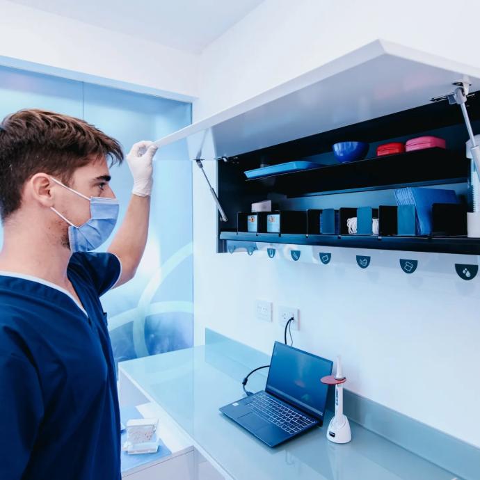 <img src="alacena-daphne.jpg" alt="Alacena expendedora modular Daphne® para consultorios odontológicos y médicos. Diseñada para almacenar y dispensar insumos descartables como guantes, barbijos, servilletas, jabón, compresas, vasos y suctores. Con puerta laqueada en color a elección, gabinete en melamina blanca o gris grafito, e indicador acrílico. Incluye estante metálico y 8 módulos dispensadores. Medidas: 1.08 x 0.31 x 0.40 m.">